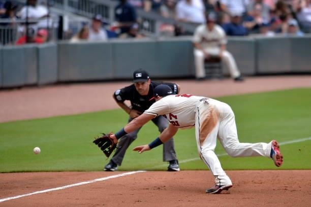 Austin Riley of the Atlanta Braves dives for a ground ball in the fifth inning against the Tampa Bay Rays at Truist Park on July 18, 2021 in Atlanta,...