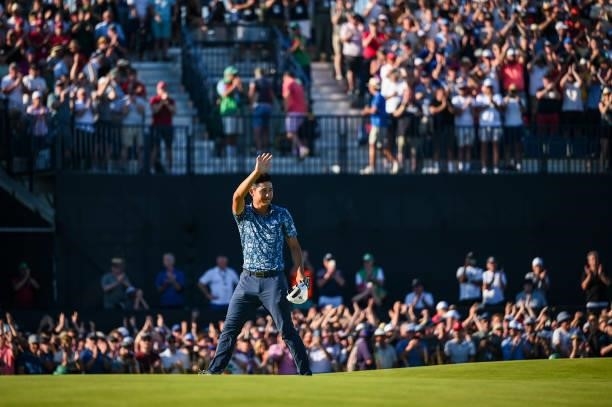 Collin Morikawa smiles and waves to fans following his two stroke victory on the 18th hole green during Day Four of the 149th The Open Championship...