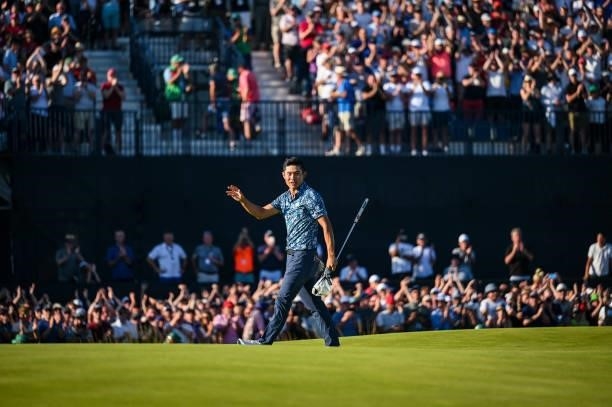 Collin Morikawa smiles and waves to fans following his two stroke victory on the 18th hole green during Day Four of the 149th The Open Championship...