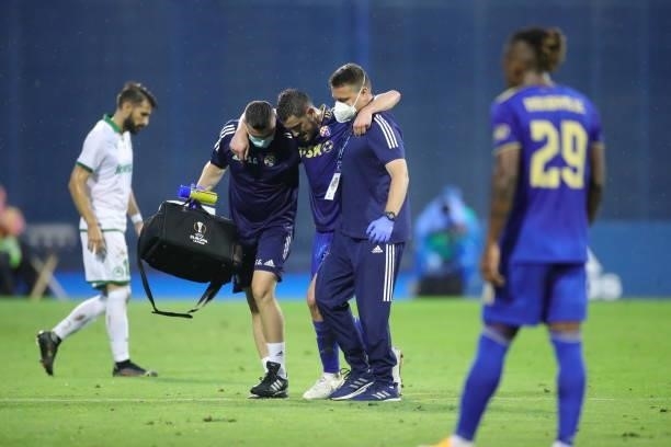 Arijan Ademi of Dinamo Zagreb leaves the pitch following an injury during the UEFA Champions League Second Qualifying Round match between GNK Dinamo...