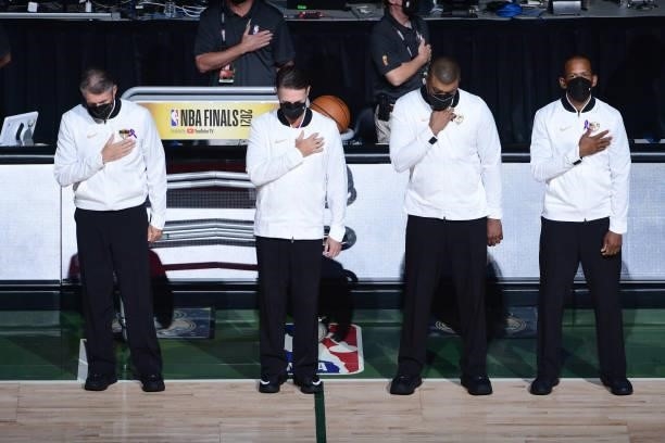 Officials Scott Foster, Pat Fraher, Tony Brothers and Eric Lewis stand for the national anthem before the Milwaukee Bucks game against the Phoenix...