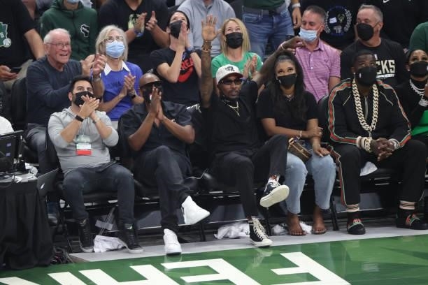 Former Milwaukee Bucks player, Brandon Jennings, celebrity, Dave Chappelle and rapper, Gucci Mane cheer during Game Six of the 2021 NBA Finals on...