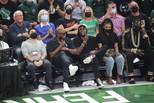 Former Milwaukee Bucks player, Brandon Jennings, celebrity, Dave Chappelle and rapper, Gucci Mane cheer during Game Six of the 2021 NBA Finals on...