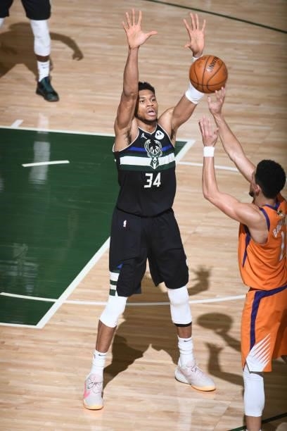 Giannis Antetokounmpo of the Milwaukee Bucks reaches to block a shot by Devin Booker of the Phoenix Suns during Game Six of the 2021 NBA Finals on...
