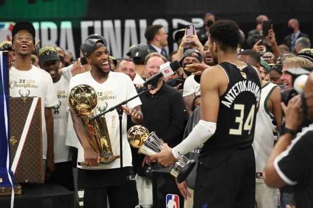 Khris Middleton of the Milwaukee Bucks celebrates with the Larry O'Brien trophy while Giannis Antetokounmpo of the Milwaukee Bucks receives the Bill...