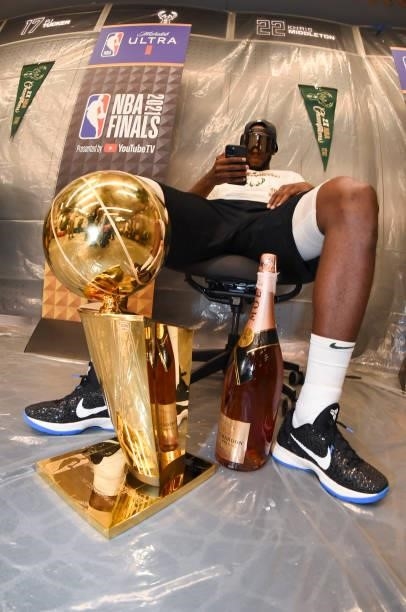 Khris Middleton of the Milwaukee Bucks and the Larry O'Brien Trophy after defeating the Phoenix Suns in Game Six to win the 2021 NBA Finals on July...