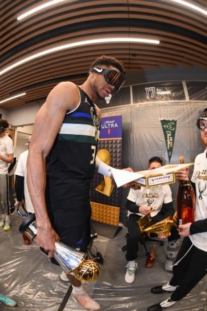 Giannis Antetokounmpo of the Milwaukee Bucks celebrates with the Bill Russell NBA Finals MVP Award after defeating the Phoenix Suns in Game Six to...