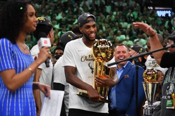 Khris Middleton of the Milwaukee Bucks celebrates with the Larry O'Brien Trophy after winning Game Six of the 2021 NBA Finals against the Phoenix...