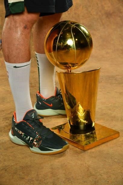 The sneakers of Brook Lopez of the Milwaukee Bucks are seen with the Larry O'Brien Trophy after winning Game Six of the 2021 NBA Finals against the...