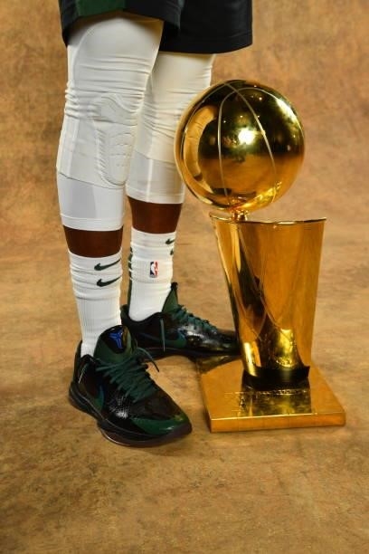 The sneakers of Jrue Holiday of the Milwaukee Bucks are seen with the Larry O'Brien Trophy after winning Game Six of the 2021 NBA Finals against the...