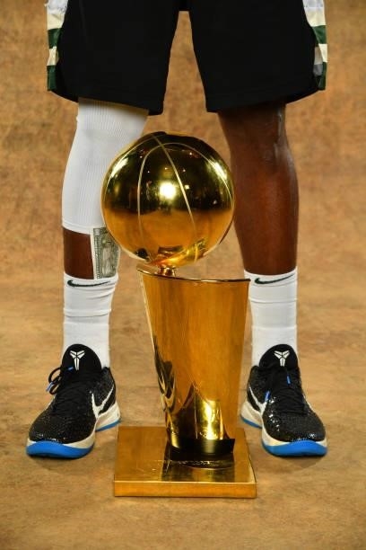 The sneakers of Khris Middleton of the Milwaukee Bucks are seen with the Larry O'Brien Trophy after winning Game Six of the 2021 NBA Finals against...