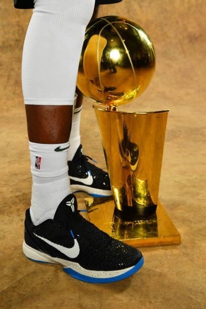 The sneakers of Khris Middleton of the Milwaukee Bucks are seen with the Larry O'Brien Trophy after winning Game Six of the 2021 NBA Finals against...
