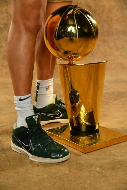 The sneakers of Bryn Forbes of the Milwaukee Bucks are seen with the Larry O'Brien Trophy after winning Game Six of the 2021 NBA Finals against the...