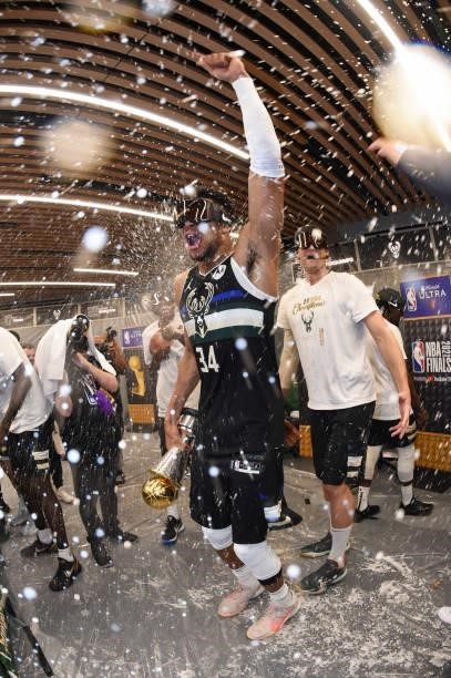 Giannis Antetokounmpo of the Milwaukee Bucks celebrates with the Bill Russell NBA Finals MVP Award after defeating the Phoenix Suns in Game Six to...