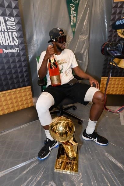 Khris Middleton of the Milwaukee Bucks sits with the Larry O'Brien Trophy after defeating the Phoenix Suns in Game Six to win the 2021 NBA Finals on...