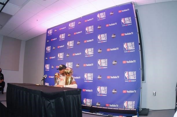 Giannis Antetokounmpo of the Milwaukee Bucks holds the Bill Russell NBA Finals MVP Award and Larry O'Brien Trophy as he talks to the media after...
