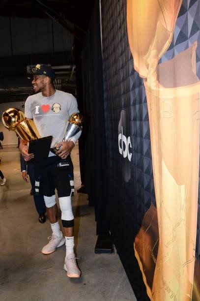 Giannis Antetokounmpo of the Milwaukee Bucks holds the Bill Russell NBA Finals MVP Award and Larry O'Brien Trophy after defeating the Phoenix Suns in...