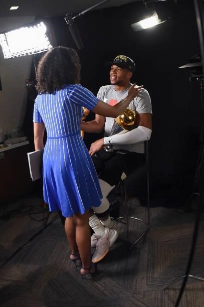 Giannis Antetokounmpo of the Milwaukee Bucks holds the Bill Russell NBA Finals MVP Award and Larry O'Brien Trophy as he talks to ESPN Sideline...