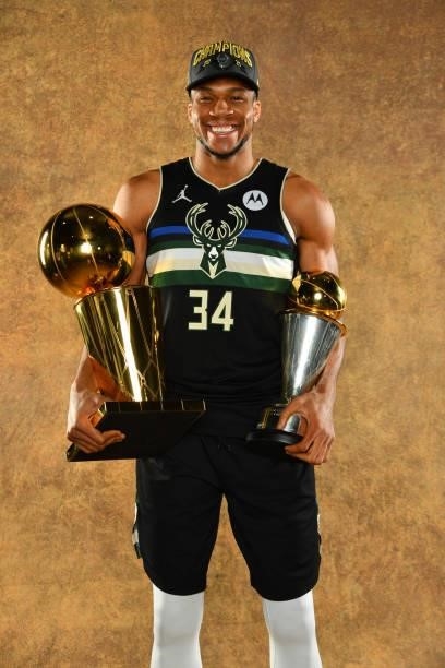 Giannis Antetokounmpo of the Milwaukee Bucks poses for a portrait with the Larry O'Brien Trophy and Bill Russell Finals MVP Award after winning Game...