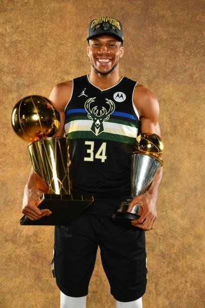 Giannis Antetokounmpo of the Milwaukee Bucks poses for a portrait with the Larry O'Brien Trophy and Bill Russell Finals MVP Award after winning Game...