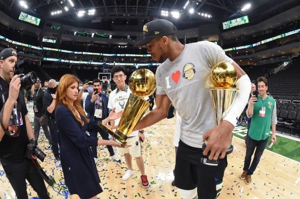 Giannis Antetokounmpo of the Milwaukee Bucks holds the Bill Russell NBA Finals MVP Award and Larry O'Brien Trophy as he talks to ESPN Reporter,...
