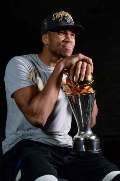 Giannis Antetokounmpo of the Milwaukee Bucks holds the Bill Russell NBA Finals MVP Award as he talks to the media after defeating the Phoenix Suns in...