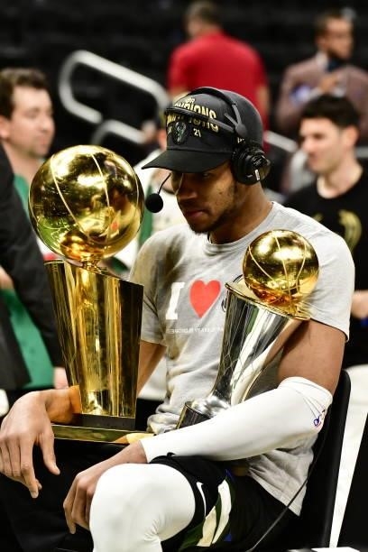 Giannis Antetokounmpo of the Milwaukee Bucks holds the Bill Russell NBA Finals MVP Award and Larry O'Brien Trophy after defeating the Phoenix Suns in...