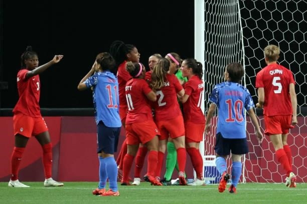 Canada's players celebrate Canada's goalkeeper Stephanie Labbe's save as Japan's forward Mina Tanaka reacts to missing a penalty shot during the...