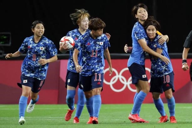 Japan's forward Mana Iwabuchi celebrates with teammates after scoring her team's first goal during the Tokyo 2020 Olympic Games women's group E first...