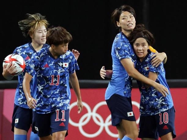 Japan's forward Mana Iwabuchi celebrates with teammates after scoring her team's first goal during the Tokyo 2020 Olympic Games women's group E first...