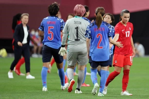 Canada's midfielder Jessie Fleming slaps hands with Japan's defender Risa Shimizu at the end of the Tokyo 2020 Olympic Games women's group E first...