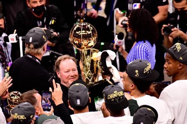 Head Coach, Mike Budenholzer of the Milwaukee Bucks hoists up the Larry O'Brien Trophy after winning Game Six of the 2021 NBA Finals against the...