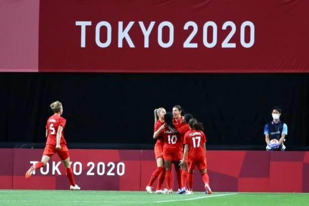 Christine of Team Canada celebrates with teammates after scoring their side's first goal during the Women's First Round Group E match between Japan...