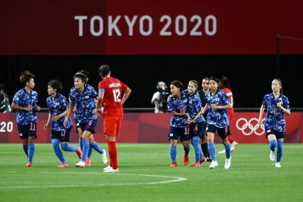 Japan team celebrates after scoring their side's first goal during the Women's First Round Group E match between Japan and Canada during the Tokyo...