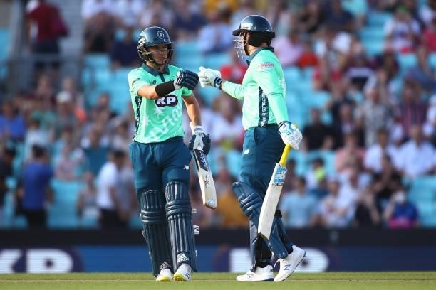 Sam Curran and Jason Roy of the Oval Invincibles bump fists during The Hundred match between Oval Invincibles Men and Manchester Originals Men at The...