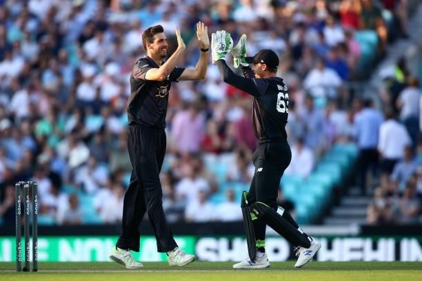 Steven Finn of the Manchester Originals celebrates taking a wicket with team mate Jos Buttler during The Hundred match between Oval Invincibles Men...