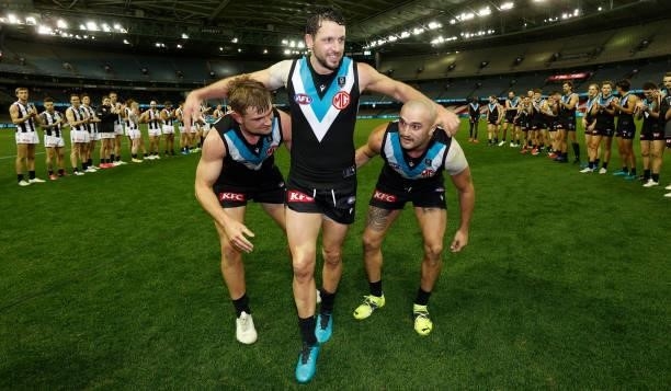 Travis Boak of the Power is chaired from the field after his 300th match by teammate Ollie Wines and Sam Powell-Pepper during the 2021 AFL Round 19...