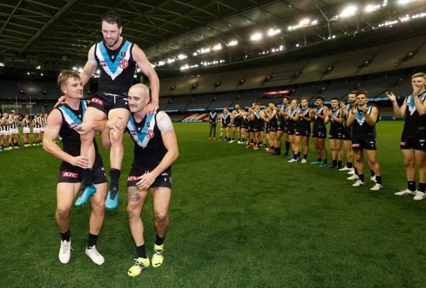 Travis Boak of the Power is chaired from the field after his 300th match by teammate Ollie Wines and Sam Powell-Pepper during the 2021 AFL Round 19...