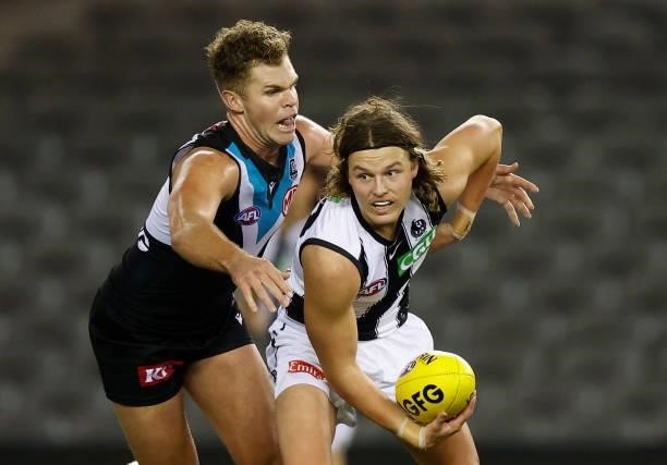 Jack Ginnivan of the Magpies is tackled by Dan Houston of the Power during the 2021 AFL Round 19 match between the Port Adelaide Power and the...