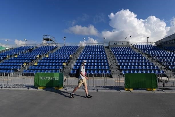 Man walks in front of the empty spectators stands at the Sea Forest Waterway rowing venue during the Tokyo 2020 Olympic Games in Tokyo on July 24,...