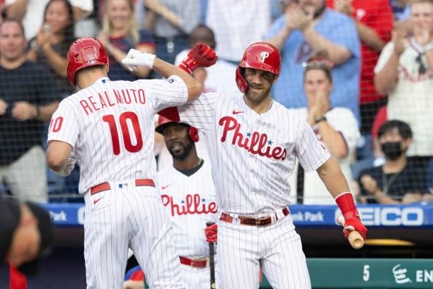 Realmuto of the Philadelphia Phillies celebrates with Bryce Harper after hitting a solo home run in the bottom of the first inning against the...