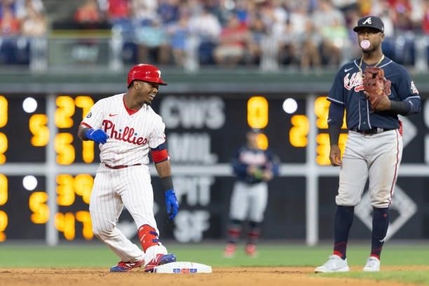 Jean Segura of the Philadelphia Phillies reacts in front of Ozzie Albies of the Atlanta Braves after hitting an RBI double in the bottom of the...
