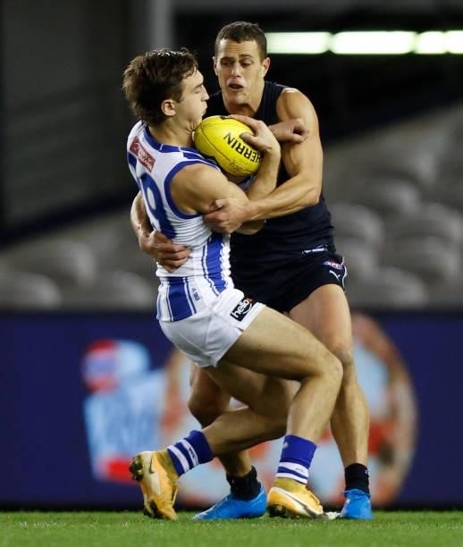 Will Phillips of the Kangaroos is tackled by Ed Curnow of the Blues during the 2021 AFL Round 19 match between the Carlton Blues and the North...