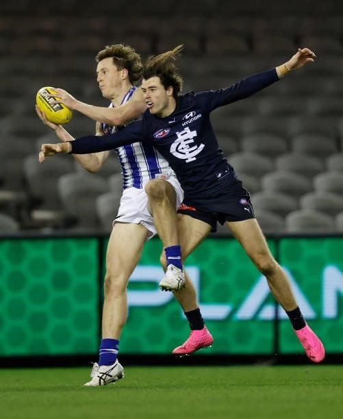 Nick Larkey of the Kangaroos and Lachie Plowman of the Blues in action during the 2021 AFL Round 19 match between the Carlton Blues and the North...