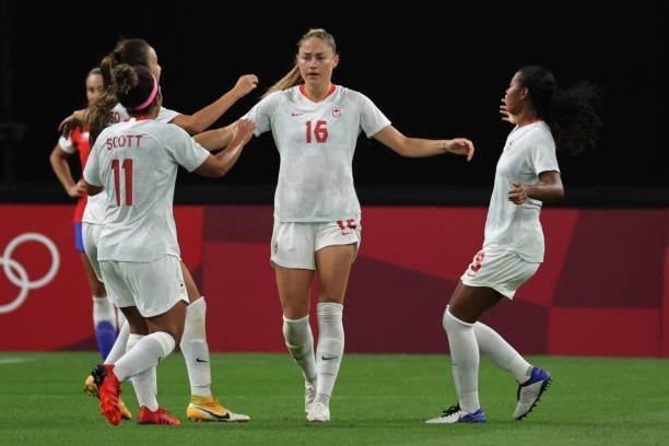 Canada's forward Janine Beckie celebrates with teammates after scoring her team's first gaol during the Tokyo 2020 Olympic Games women's group E...