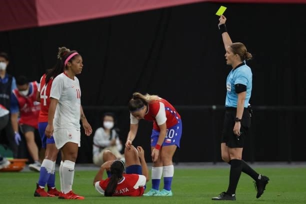 Swiss referree Esther Staubli shows a yellow card to Canada's midfielder Desiree Scott during the Tokyo 2020 Olympic Games women's group E first...