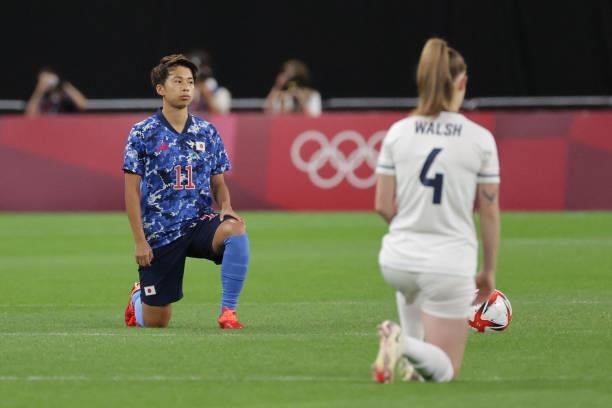 Japan's forward Mina Tanaka and Britain's midfielder Keira Walsh takes a knee before the start of the Tokyo 2020 Olympic Games women's group E first...