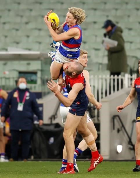Cody Weightman of the Bulldogs takes a spectacular mark over Max Gawn of the Demons during the 2021 AFL Round 19 match between the Melbourne Demons...
