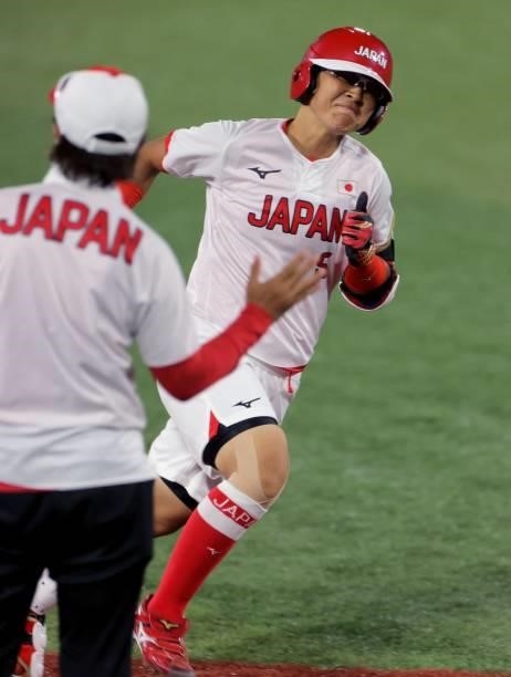 Japan's third base player Yu Yamamoto is congratulated by Japan's head coach Reika Utsugi on her two run homer during fourth inning of the Tokyo 2020...