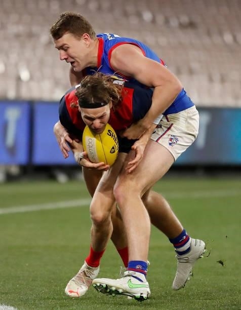 Ed Langdon of the Demons is tackled by Jack Macrae of the Bulldogs during the 2021 AFL Round 19 match between the Melbourne Demons and the Western...